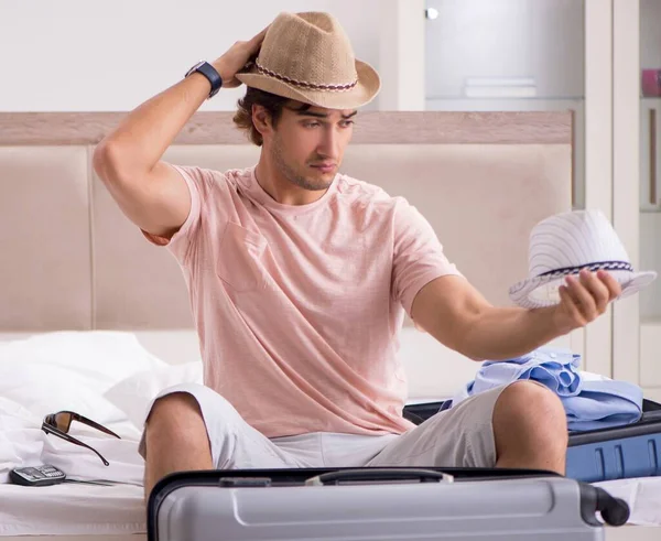 Yatak odasında bavullu adam geziyi bekliyor.