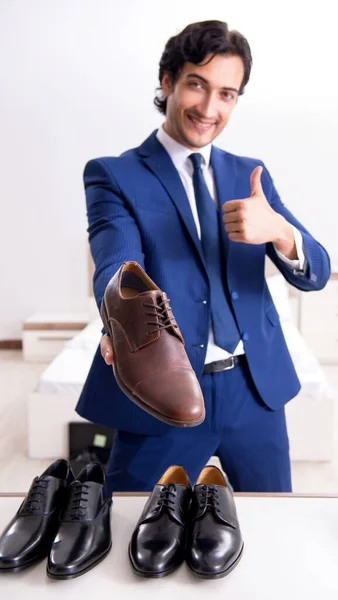 Jovem empresário bonito escolhendo sapatos em casa — Fotografia de Stock