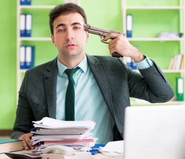 İşadamı ofiste otururken aşırı çalışmaktan kızgın.