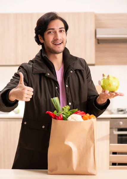 El joven guapo con verduras en la cocina —  Fotos de Stock