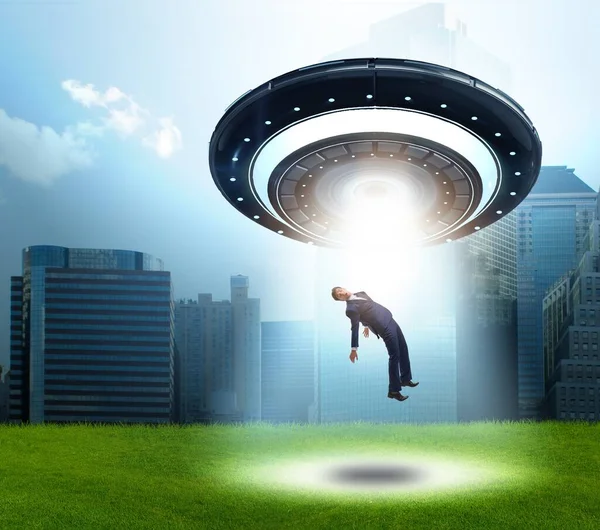 Flying saucer abducting young businessman — Stock Photo, Image