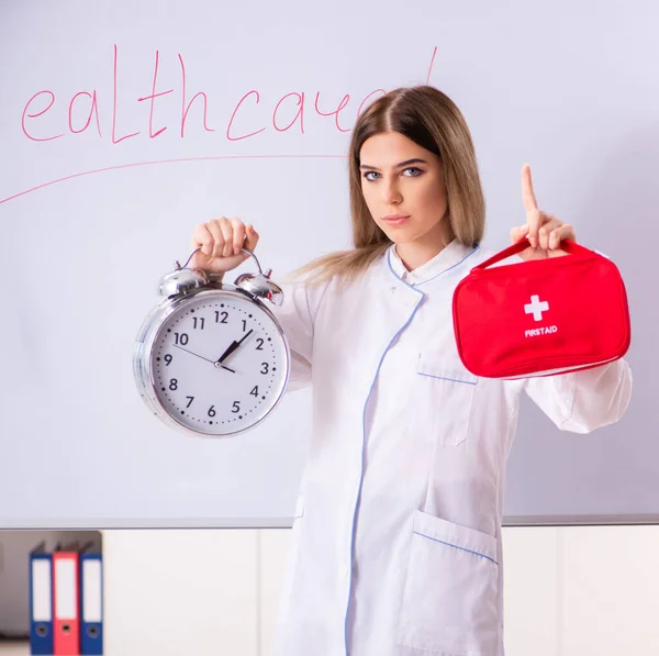 Den unga kvinnliga läkaren står framför den vita tavlan — Stockfoto