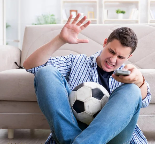 Jovem estudante assistindo futebol em casa — Fotografia de Stock