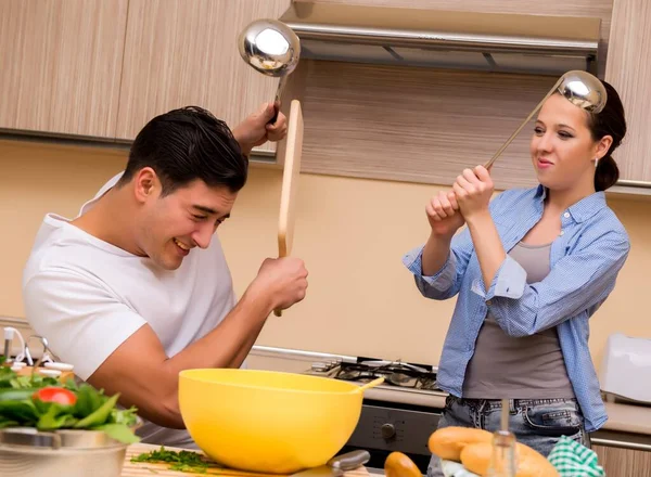 Jovem família fazendo luta engraçada na cozinha — Fotografia de Stock