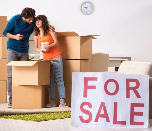 Joven familia ofreciendo casa para la venta y mudanza — Foto de Stock