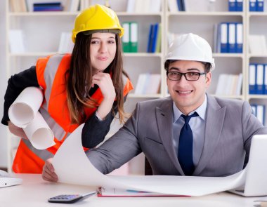 İnşaat ustabaşı çizimleri gözden geçiriyor