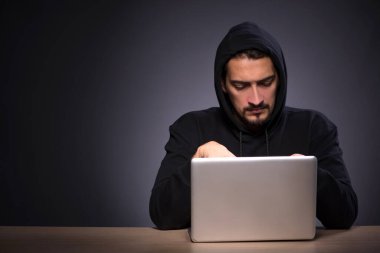 Gri arka planda genç erkek hacker