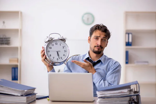 Joven empleado masculino en concepto de gestión del tiempo —  Fotos de Stock