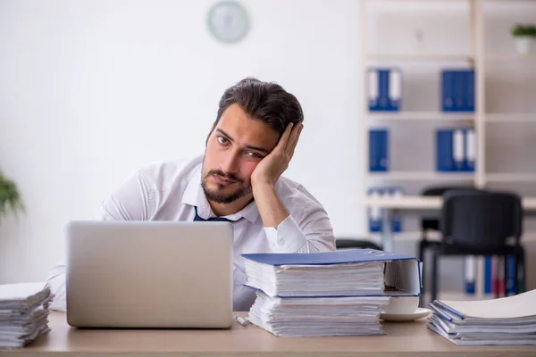 Giovane dipendente maschio infelice con un lavoro eccessivo in ufficio — Foto Stock