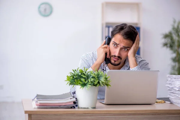 Ung manlig anställd missnöjd med överdrivet arbete på kontoret — Stockfoto