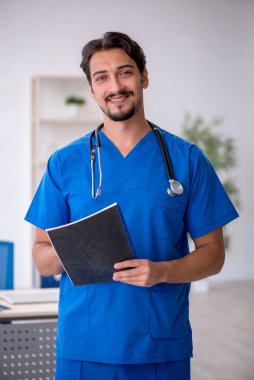 Klinikte çalışan genç erkek doktor.