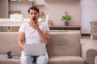 Genç erkek çalışan salgın sırasında evden çalışıyor.