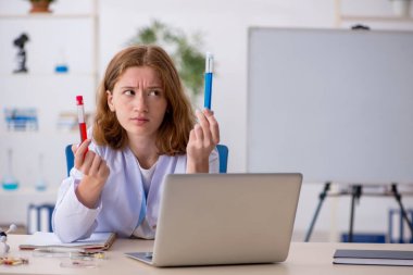 Laboratuarda çalışan genç bir kadın kimyager.