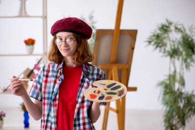 Genç kız evde resim yapmaktan hoşlanıyor.