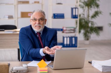 Ofiste çalışan yaşlı bir erkek.