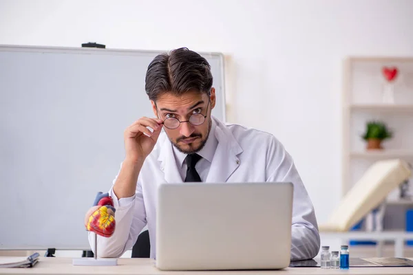 Jonge mannelijke arts cardioloog zit in de klas — Stockfoto