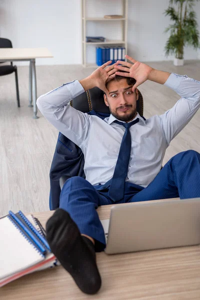 Jonge mannelijke werknemer zeer moe in het kantoor — Stockfoto