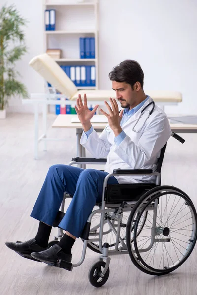 Joven médico en silla de ruedas que trabaja en la clínica — Foto de Stock