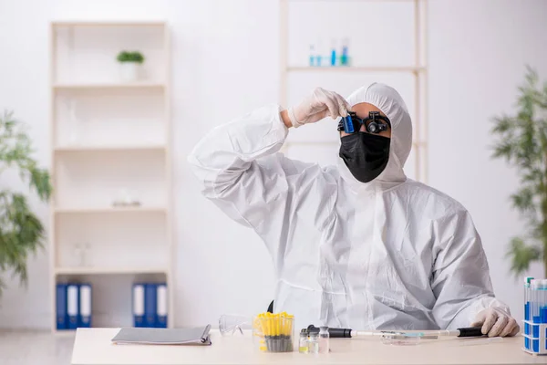 Joven químico trabajando en el laboratorio durante una pandemia —  Fotos de Stock