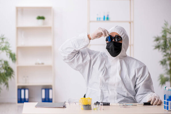 Young male chemist working at the lab during pandemic