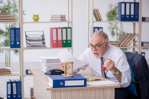 Old male employee in time management concept — Stock Photo, Image