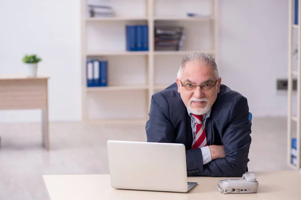 Ancien employé masculin travaillant dans le bureau — Photo