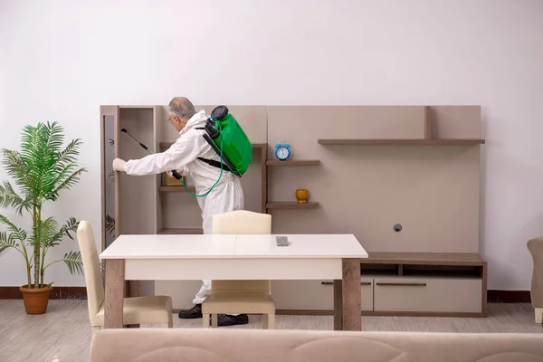 Old male contractor doing pest control at home — Stock Photo, Image