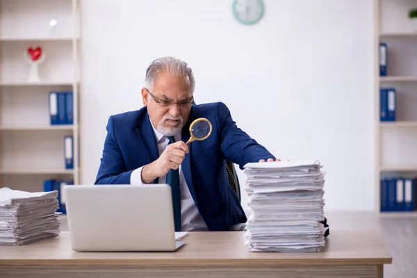 Velho empregado masculino e muito trabalho no escritório — Fotografia de Stock