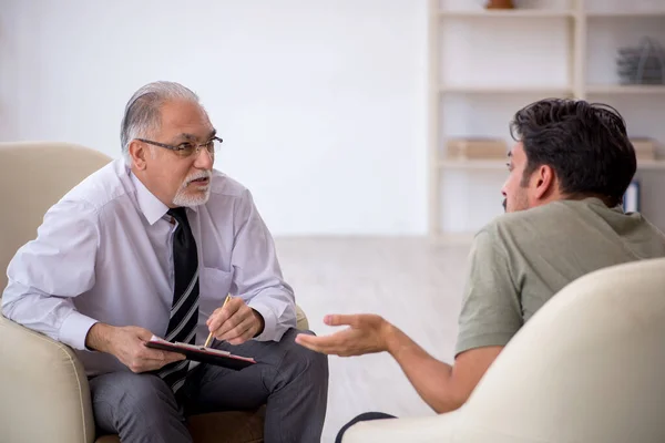 Jongeman op bezoek bij oude psycholoog — Stockfoto