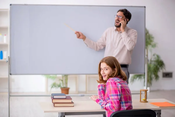 Jong man leraar en roodharige meisje in de klas — Stockfoto