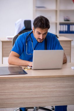 Klinikte çalışan genç erkek doktor.