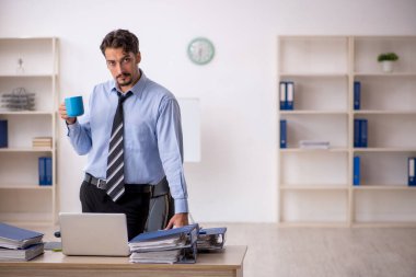 Molada kahve içen genç bir erkek.