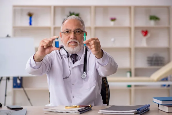 Gammal manlig läkare som arbetar på kliniken — Stockfoto