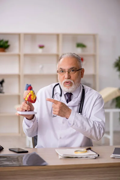 Klinikte çalışan yaşlı bir erkek kardiyolog. — Stok fotoğraf