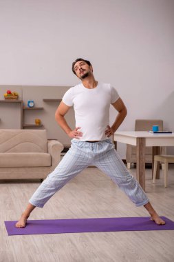 Genç adam evde spor yapıyor.