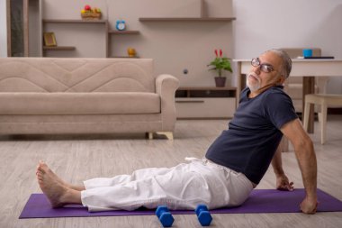 Yaşlı adam evde spor yapıyor.