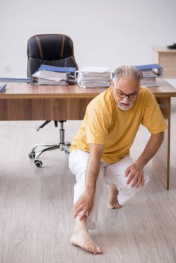 Ofiste spor egzersizleri yapan eski bir işadamı.