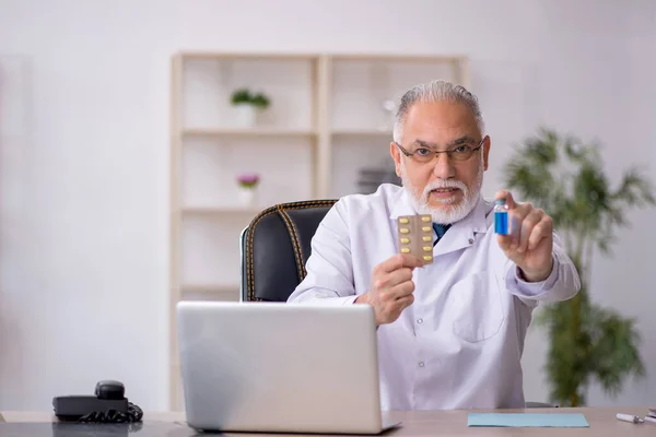 Klinikte çalışan yaşlı erkek doktor. — Stok fotoğraf