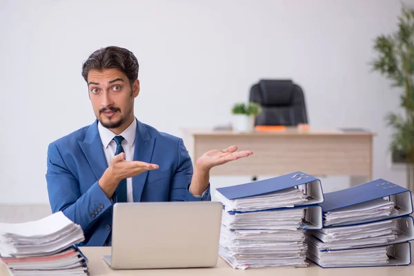 Junge männliche Mitarbeiter und zu viel Arbeit im Büro — Stockfoto