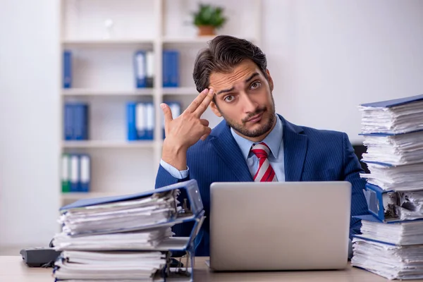 Jeune employé masculin et trop de travail au bureau — Photo