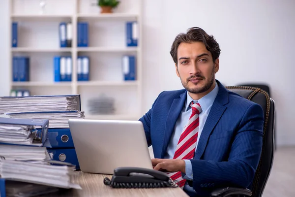 Jeune employé masculin et trop de travail au bureau — Photo