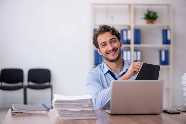 Jeune employé masculin et trop de travail au bureau — Photo