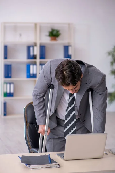 Jovem empregado masculino após acidente de carro que trabalha no escritório — Fotografia de Stock