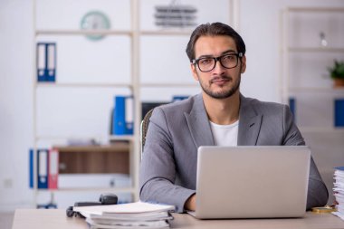 Ofiste çalışan genç bir erkek.