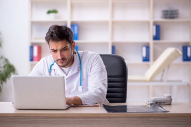 Klinikte çalışan genç erkek doktor.