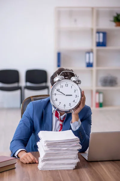 Joven empleado masculino en concepto de gestión del tiempo — Foto de Stock