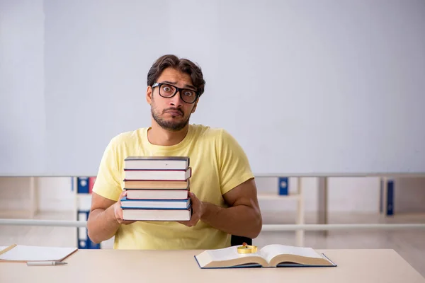 Jonge mannelijke student bereidt zich voor op examens in de klas — Stockfoto