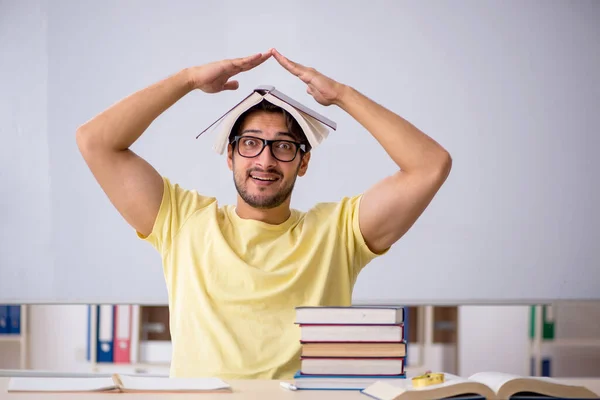 Jonge mannelijke student bereidt zich voor op examens in de klas — Stockfoto