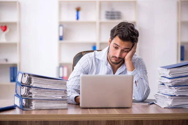 Jovem funcionário masculino infeliz com excesso de trabalho no escritório — Fotografia de Stock