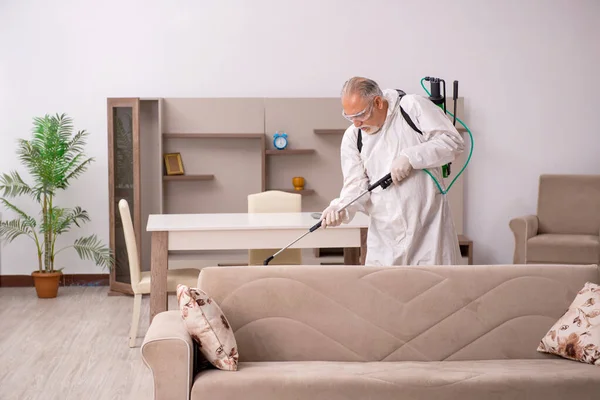 Stary mężczyzna wykonawca robi zwalczanie szkodników w domu — Zdjęcie stockowe